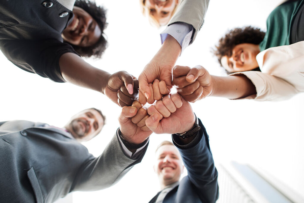 team putting hands together representing team work